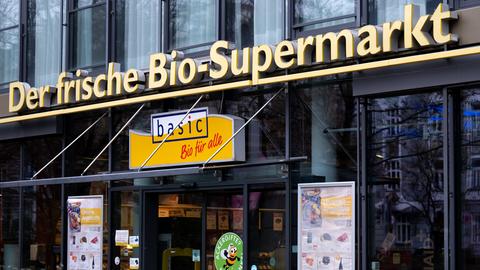 Eingang einer Filiale der Biosupermarktkette Basic, mit viel Glas und gelbem Schild
