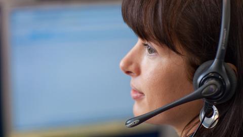 Eine Frau mit Headset in einem Callcenter