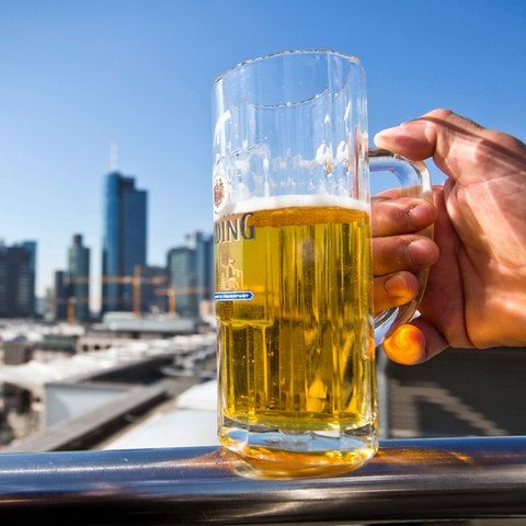 Ein Binding Bier im Glas vor der Frankfurter Skyline.