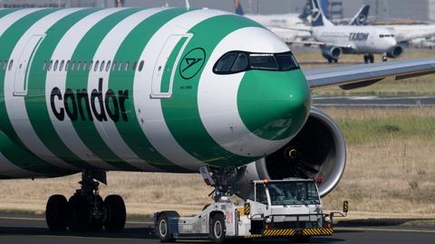 Ein Flugzeug, das mit grün-weißen Kreisen lackiert ist, fährt über ein Rollfeld am Flughafen Frankfurt.
