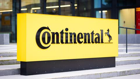 Ein gelbes Schild mit der Aufschrift "Continental" steht vor einer Unternehmenszentrale.