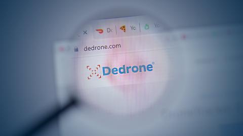 Foto eines Browserfensters, in welchem "DeDrone" steht. Drüber liegt unscharf eine Lupe. Das Bild verdunkelt sich nach außen, in der Mitte ist es heller.