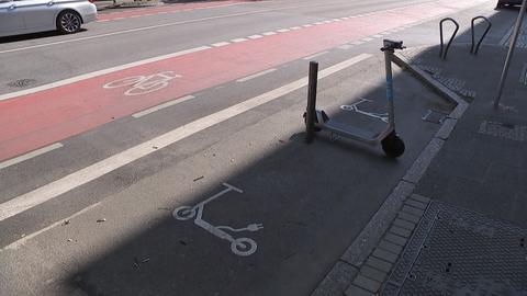 Auf einer Fläche an einer Straße steht ein E-Scooter, daneben ist ein E-Scooter-Symbol auf die Parkzone gemalt