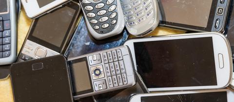 Alte Smartphones liegen auf einem Tisch