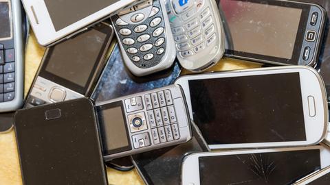 Alte Smartphones liegen auf einem Tisch