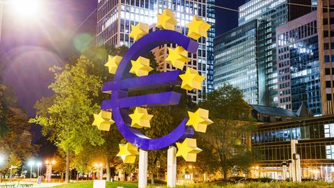 Das Eurozeichen ist in der Nacht beleuchtet.