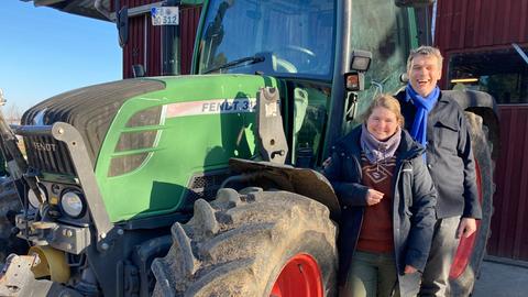 Lara Ewald, Landwirtschaftsmeisterin Biohof Ewald und Martin von Mackensen, Landwirt Dottenfelderhof - stehen lachend neben einem grünen Fendt-Traktor