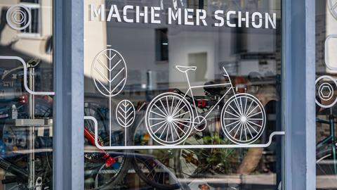 "Mache mer schon" ("Machen wir schon") steht auf hessisch am Schaufenster eines Fahrradgeschäftes am Rande der Innenstadt Frankfurts.