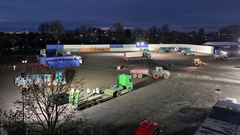 Baustellengelände bei Nacht mit aufeinandergestapelten Containern
