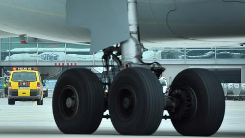 Ein sogenanntes Follow-Me-Fahrzeug der Vorfeldaufsicht fährt über das Rollfeld auf dem Flughafen von Frankfurt und lotst dabei eine Passagiermaschine an ihre Parkposition. 