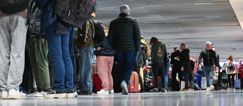 Zahlreiche Fluggäste stehen im Terminal 1 im Flughafen Frankfurt vor einem Informationsschalter der Lufthansa Schlange.