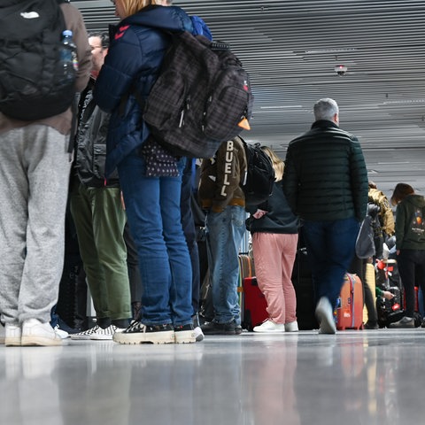 Zahlreiche Fluggäste stehen im Terminal 1 im Flughafen Frankfurt vor einem Informationsschalter der Lufthansa Schlange.
