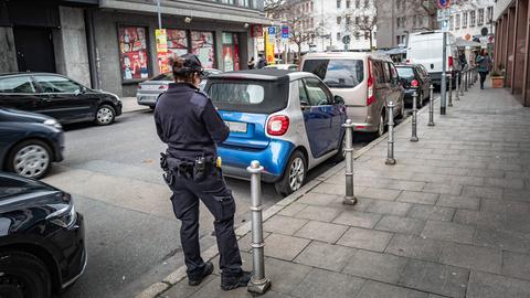 Eine Mitarbeiterin des Ordnungsamts notiert einen falsch parkenden Pkw.