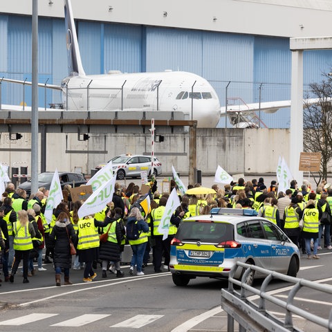 Streikende Flugbegleiter mit Bannern und Ufo-Fahnen am Frankfurter Flughafen.