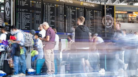 Passagiere warten auf dem Flughafen in Frankfurt auf ihren Check-In.