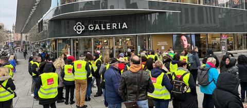 Menschen in Verdi-Westen stehen am Ostersamstag vor der Galeria Filiale in Frankfurt