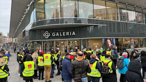 Menschen in Verdi-Westen stehen am Ostersamstag vor der Galeria Filiale in Frankfurt