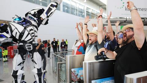 Computerspiel-Fans warten jubelnd am Morgen am Eingang der Messe.