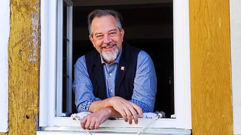 Peter Stuertz, der Geschäftsführer der Gastronomie im Hessenpark, lehnt lächelnd aus einem Fenster.