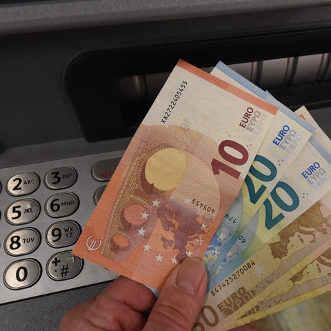 Geldscheine werden an einem Geldautomaten abgehoben