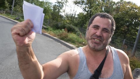 Mann freut sich und hält Papiere in der Hand