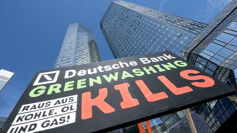 «Deutsche Bank - Greenwashing kills, raus aus Kohle, Öl und Gas!» steht auf einem Plakat, das Umweltaktivisten von Fridays for Future vor der Zentrale der Deutschen Bank aufgestellt haben.