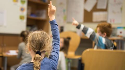 Ein Mädchen meldet sich im Unterricht in einer Grundschule in Eltville