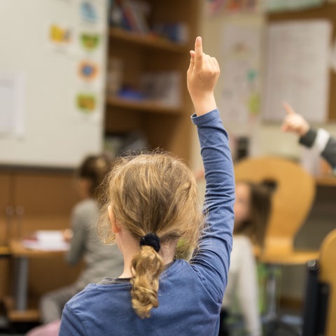 Ein Mädchen meldet sich im Unterricht in einer Grundschule in Eltville