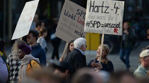 "Hartz 4, das ward ihr": Eine Frau hält ein Schild bei einem Protest gegen eine SPD-Wahlkampfveranstaltung in Kassel im Jahr 2017. 