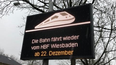 "Die Bahn fährt wieder vom Hbf Wiesbaden." steht auf einem Schild, aufgestellt im Stadtraum.