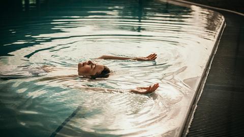 Eine Frau liegt in einem Pool.