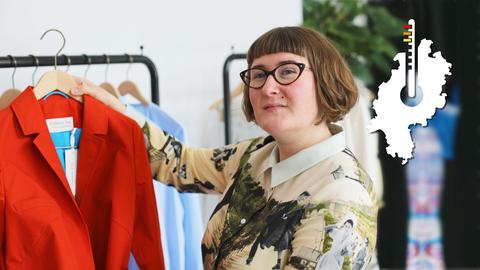 Designerin Galatea Ziss hält eine rote Jacke ihrer Kollektion hoch.