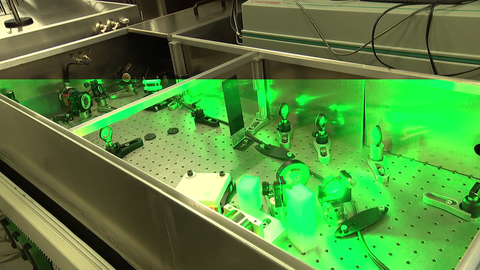 In einer Metallbox leuchtet grünes Laserlicht.
