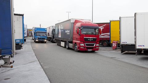 LKWs, die in Reihe auf einem Parkplatz stehen.