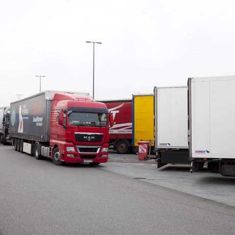 LKWs, die in Reihe auf einem Parkplatz stehen.