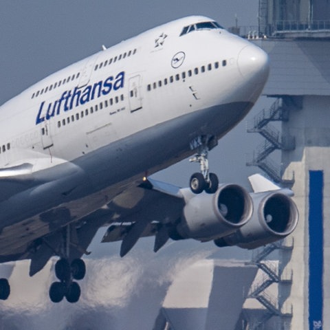 Lufthansa-Boeing 747 startet vor dem Tower des Frankfurter Flughafens.