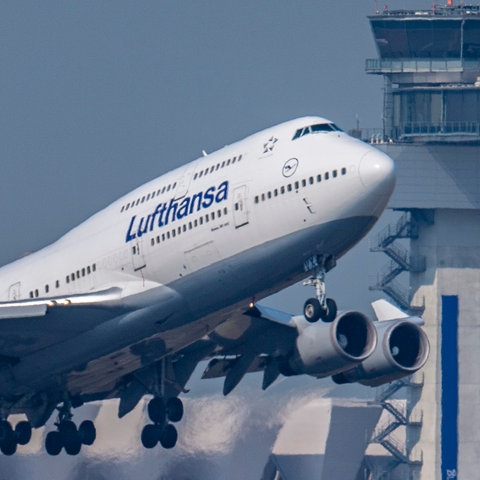 Un Boeing 747 Lufthansa decolla davanti alla torre dell'aeroporto di Francoforte.