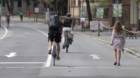 Fußgänger und Radfahrer auf dem für den Autoverkehr gesperrten Mainkai in Frankfurt