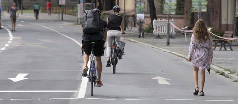 Fußgänger und Radfahrer auf dem für den Autoverkehr gesperrten Mainkai in Frankfurt