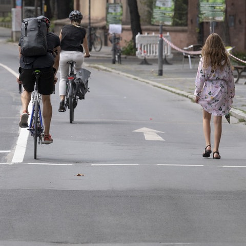 Fußgänger und Radfahrer auf dem für den Autoverkehr gesperrten Mainkai in Frankfurt