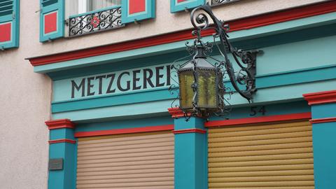 Das Bild zeigt eine Straßenlaterne und die Inschrift "Metzgerei" an einem Fachwerkhaus in Steinau an der Straße.