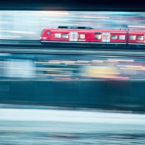 Ein Zug fährt über eine Brücke in Frankfurt