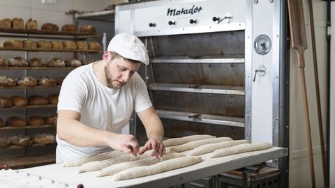 Nick Heinke, Mann mit Bart beim Baguette-Backen