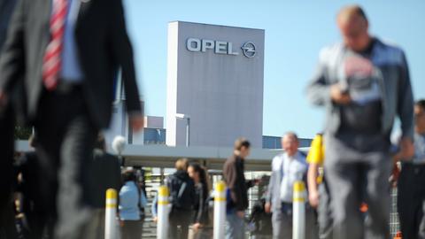 Menschen vor dem Opel-Turm in Rüsselsheim.