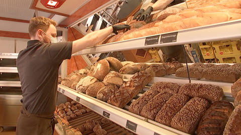 Henrik Markus steht in seiner Hauptfiliale und räumt Brot in die Regale.