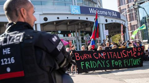 Ein Polizist beobachtet junge Demonstranten von "Fridays for Future".