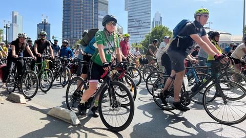 Teilnehmer der Fahrrad-Demonstration in Frankfurt fahren auf einer Straße, im Hintergrund sind die Banekentürme zu sehen