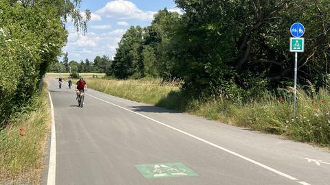 Radschnellweg zwischen Frankfurt und Darmstadt - bislang ist nur ein Teilabschnitt fertig, auf dem ist das Foto entstanden. Im Hintergrund drei Radler. 
