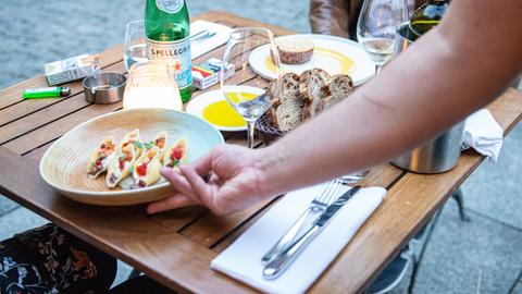 Ein Kellner serviert Essen in einem Restaurant.