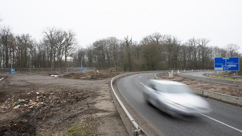 Ein Auto fährt auf der A66 an der Stelle vorbei, an der die Autobahn durch den Riederwaldtunnel unter dem Fechenheimer Wald erweitert werden soll. 